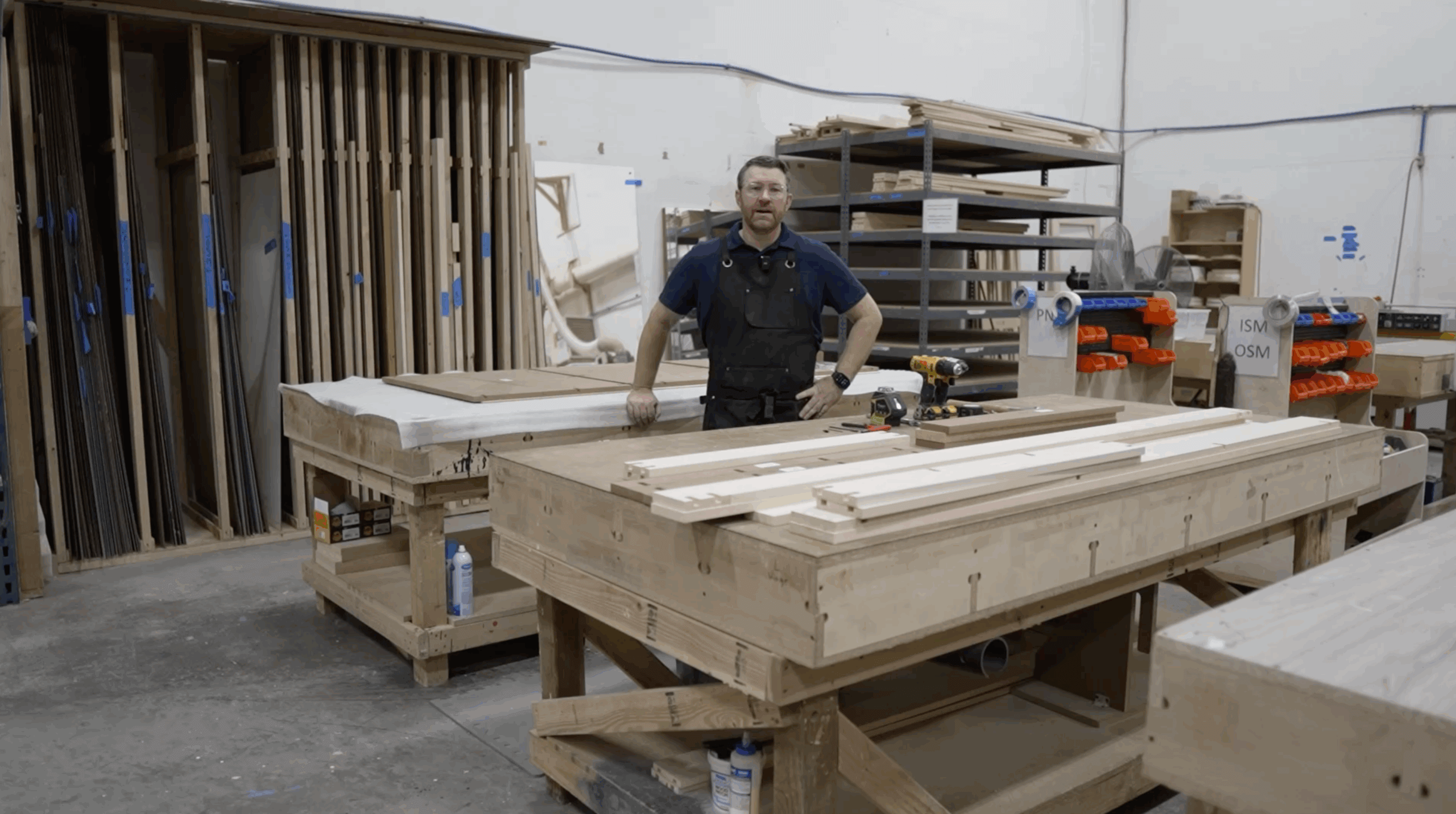 Travis, an owner of Hidden Door Store, standing with a DIY Mirror Door ready to be assembled.